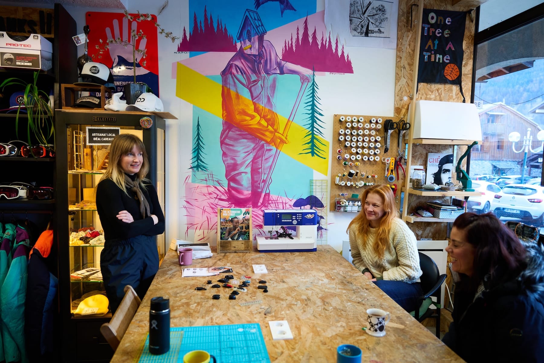 Image shows two women discussing clothes repair and re-purposing at the One Tree shop.