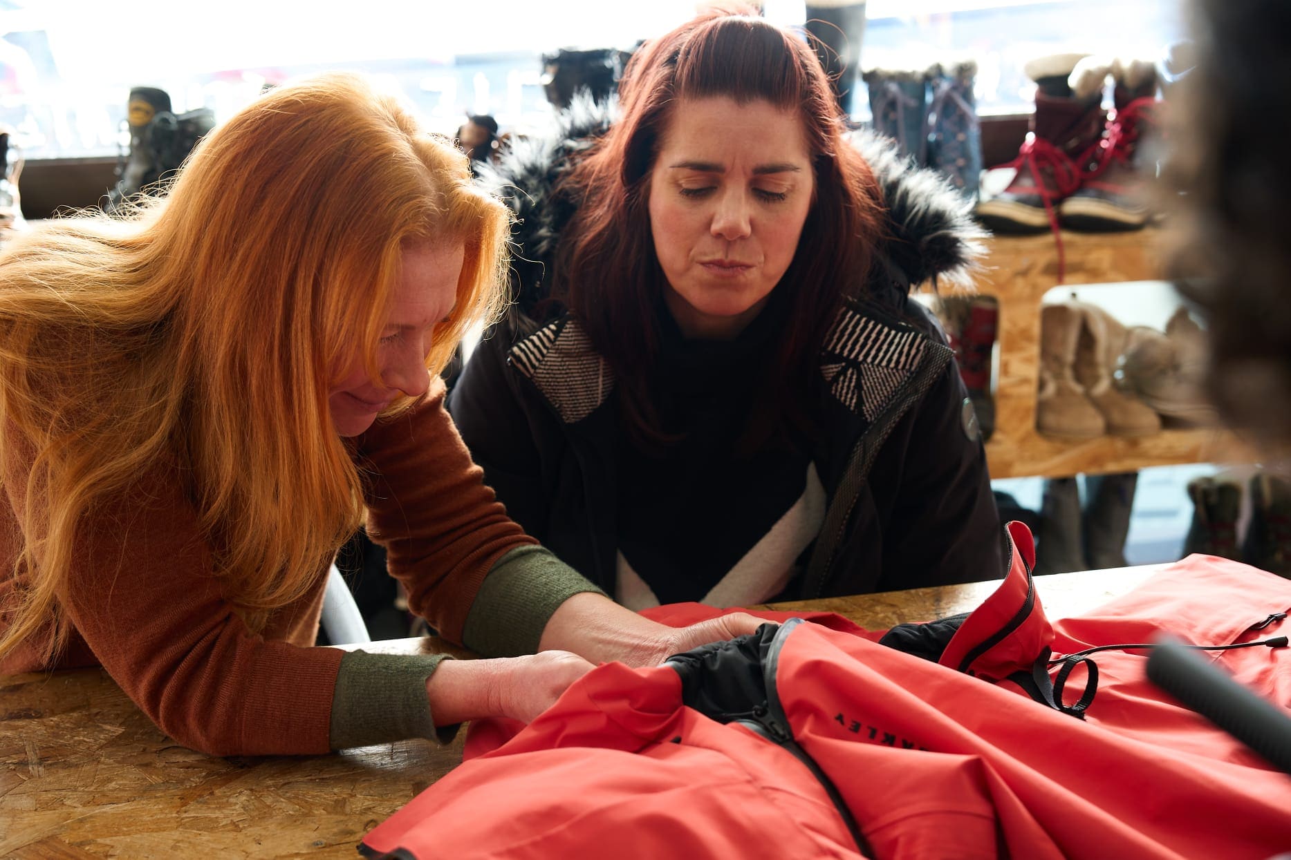 Kelly and Justine inspect an adaptive ski jacket