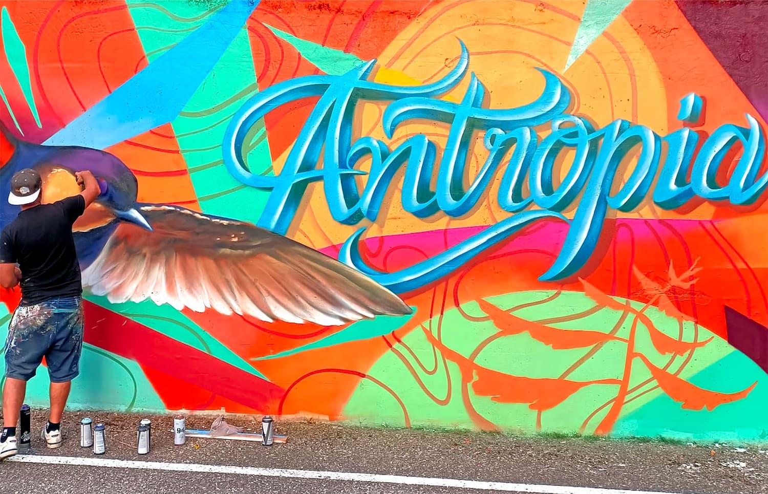 A street artist creating a colourful Antropia mural